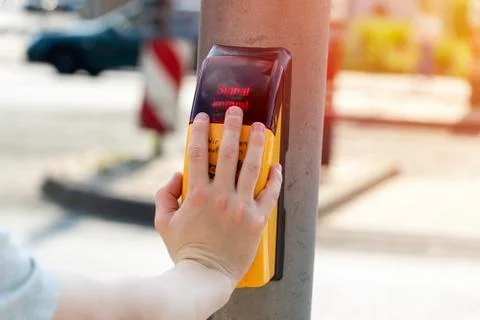Child presses traffic light button to cross the road Stock Photos