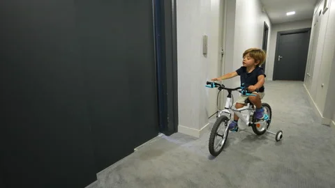 Child pressing elevator button entering with bicycle Video stock 183025723