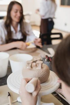 Child in the process of decorating the clay vase. Children pottery studio. Stock Photos