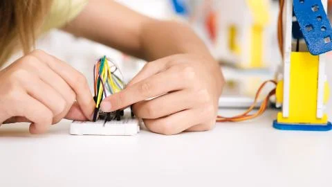 Child programming robot, working with wires, closeup Stockfoto's