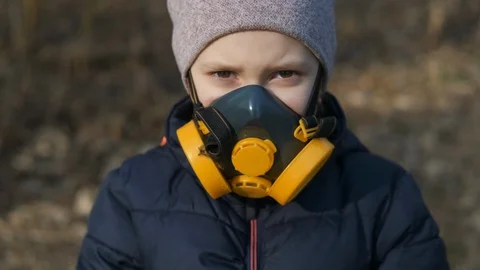 Child in protective mask, face-guard to prevent breathing toxic air.  Stock-Footage 129592848