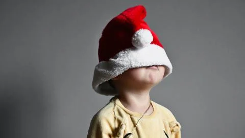 The child pulled a Christmas hat over his eyes Foto stock