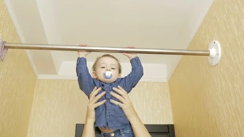 Child pulling up on horizontal bar installed at home. Stock Footage 127198956