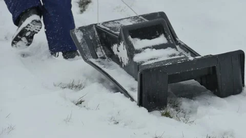 Child pulling sled up snow covered hill on a winter day sledding close up Stock Footage 151002563