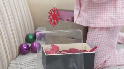 A child pulls Christmas tree balls out of a box Stock Footage 224022424