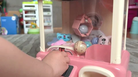 Child pulls a claw crane game machine with toys. Stock Footage 311560159