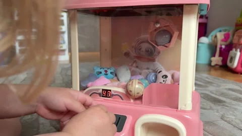 Child pulls a claw crane game machine with toys. Video stock 311560171