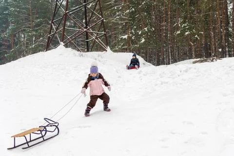 Child pulls sledding uphill Stock Photos