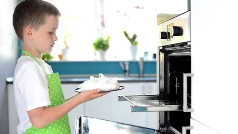 Child puts the cake to the oven Stock Footage 76531808