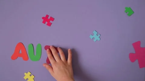 The child puts letters on a purple background forming the word autism. Stock Footage 329185798