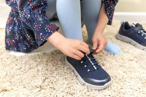 The child puts on sneakers. Stock Photos