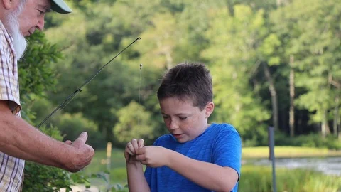 Child putting bait on a hook to go fishing. Stock-Footage 115343505
