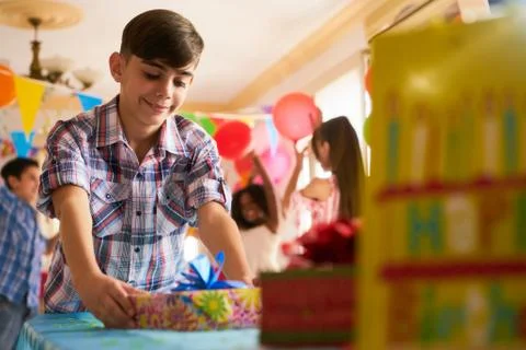 Child Putting Present On Table During Birthday Party At Home Stock Photos