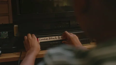 Child Putting Zombie Attack Cassette into VHS While Alone at Home in 90s Stock Footage 273743545