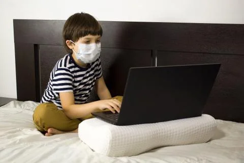 A child in quarantine performs online training. Homework at home. Stock Photos