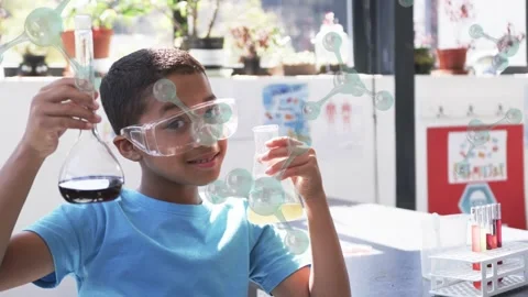 Child raising flasks and inspecting liquids for class at lab bench, molecules Stock Footage 333911110