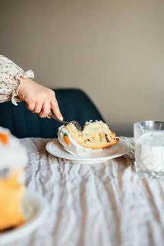 Child reaching for a slice of panettone at a table. Foto stock