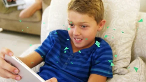 Child reaching for tablet home, playing with app as green triangles overlaying Stock Footage 333035197