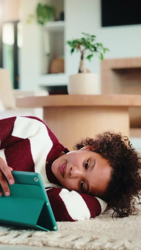 Child, reading and relax with tablet in house, elearning or skill development Stock Footage 335850841