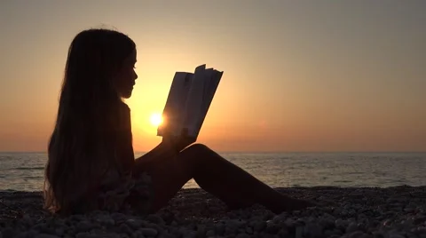Child Reading Book on Beach, Kid at Sunset, Little Girl on Coastline, Ocean View Stock Footage