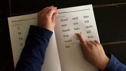 Child reading a book, points to the words Stock Footage 70145117