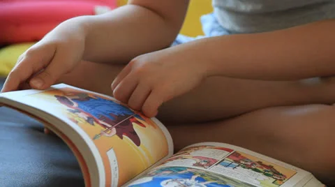 Child reading comic book Stock Footage 24560265