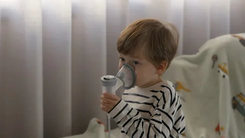 Child Receiving Inhalation Therapy, Sitting In Cozy Home Setting With Blanket Stock Footage 293589019