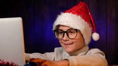 Child in a red hat writes letter to Santa Claus on laptop on Christmas Eve. Stock Footage 162989875