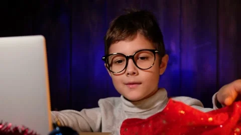 Child in a red hat writes letter to Santa Claus on laptop on Christmas Eve. Stock Footage 163770250
