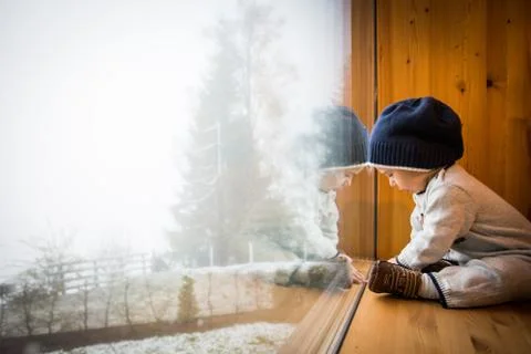 Child Reflection on Large Window overlooking Winter Landscape Stock Photos