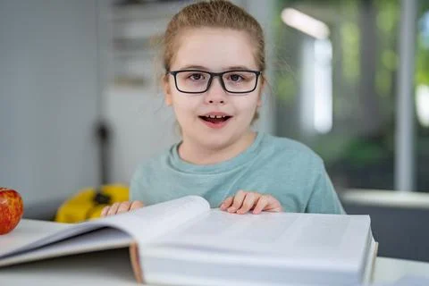 Child relaxing while reading a book at home. Happy kid read book in a home Stock Photos