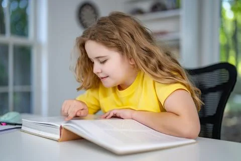Child relaxing while reading a book at home. Happy kid read book in a home Stock Photos