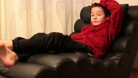Child with remote controller lying on a sofa Stock Footage 72382471