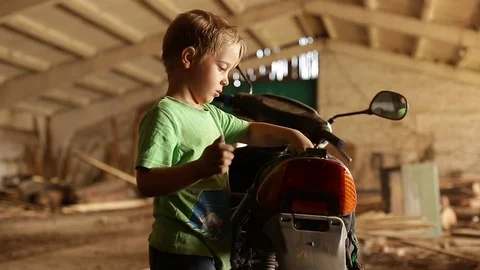 A child repairs a scooter. Stock Footage 129085327