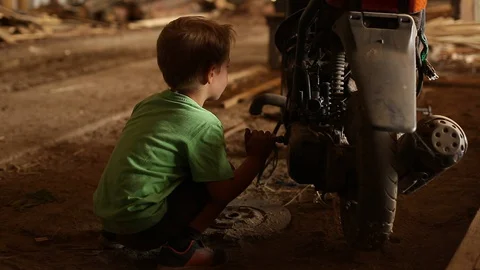 A child repairs a scooter. Stock Footage 129085821