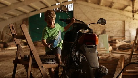 A child repairs a scooter. Stock Footage 129086254