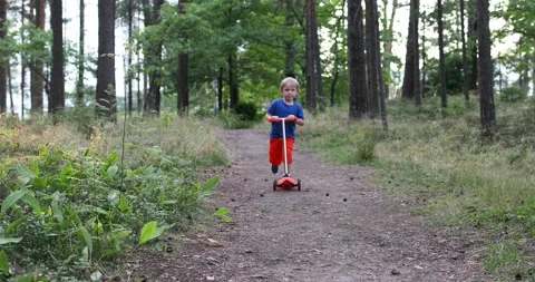 Child ride scooter in forest path and fall, it hurts to hit his head and cry. Stock Footage 146167651