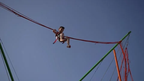 Child rides on bungee trampoline. Concept of fun attractions. Stock Footage 293152111