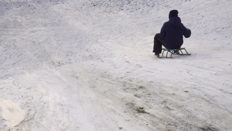 A child rides a sled down in slow motion. Stock Footage 166162549