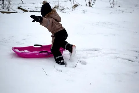 The child rides on a sled. Stock Photos