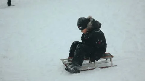Child rides a sled through the snow to the mountains Stock Footage 10731064