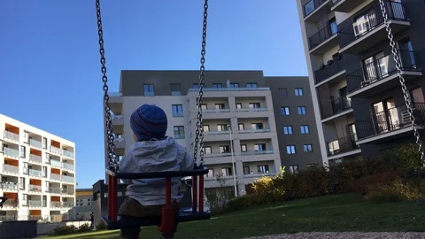 The child rides on a swing. View from back. Stock Footage 98347973