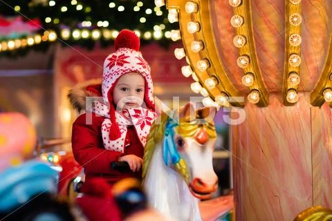 Child riding carousel on Christmas market Stock Photos