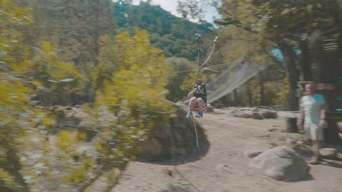 Child riding an exciting zip line in an adventure park. Smooth tracking shot Stock Footage 88903705