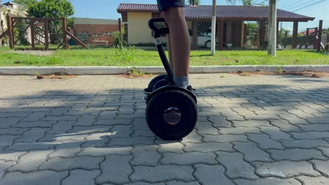 Child riding hoverboard on pavement, side follow tracking shot, slow motion 4K60 Video stock 331196275
