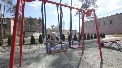Child riding on a swing on playground Stock Footage 73289865