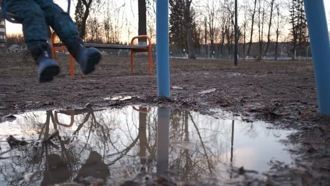 The child is riding on a swing in the playground Stock Footage 107726332