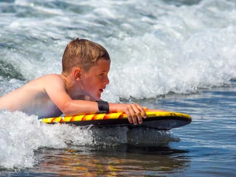 Child riding waves Stock Photos