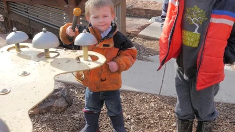 Child ringing a bell at a park. Stock Footage 71635590