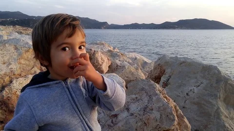 Child on rocks and his chewing-gum, 2 Stock Footage 71023745